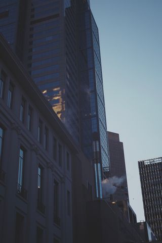 A view of buildings with smoke coming out of vents.