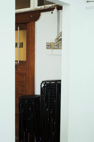 Chairs stacked in the corner of BLINDSIDE gallery.